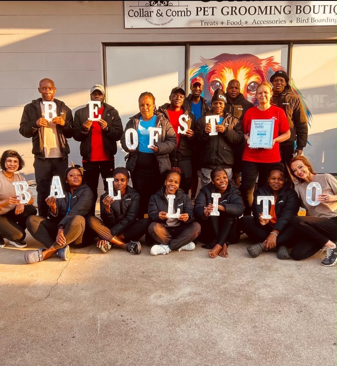The Collar & Comb staff holding letters that spell BEST OF BALLITO, with their winner's certificate